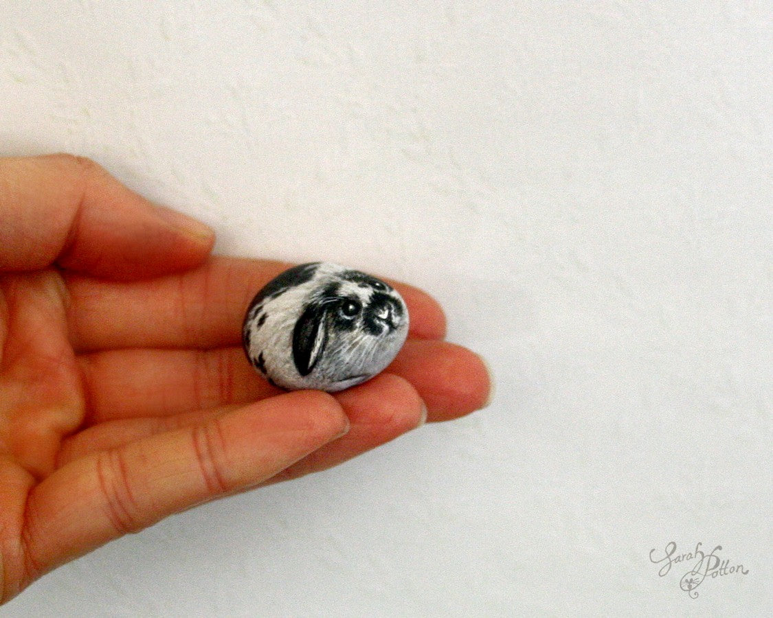 miniature painted pebble of black and white bunny