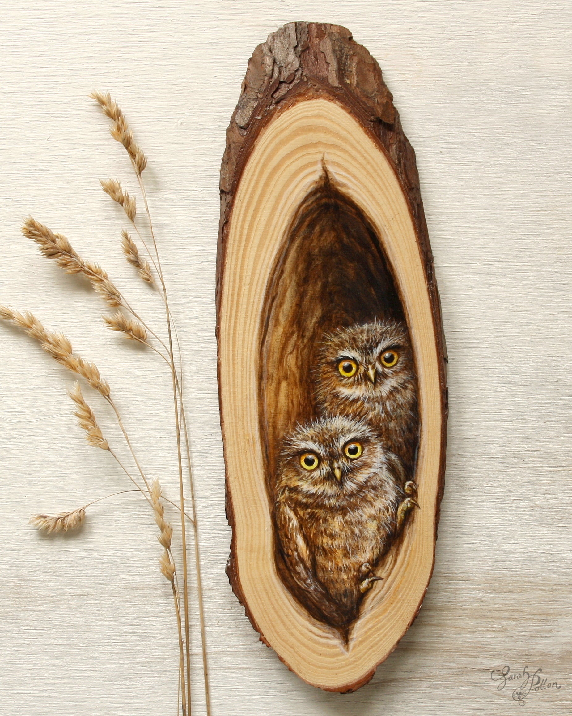 Wooden artwork with baby owls inside hollow tree