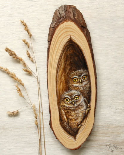 Wooden artwork with baby owls inside hollow tree