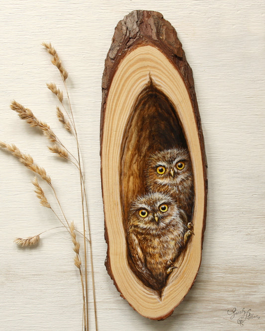 Wooden artwork with baby owls inside hollow tree
