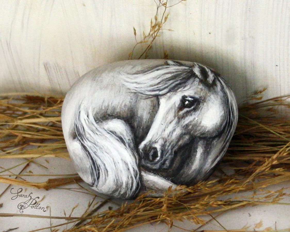 realistic white horse painting on a rock