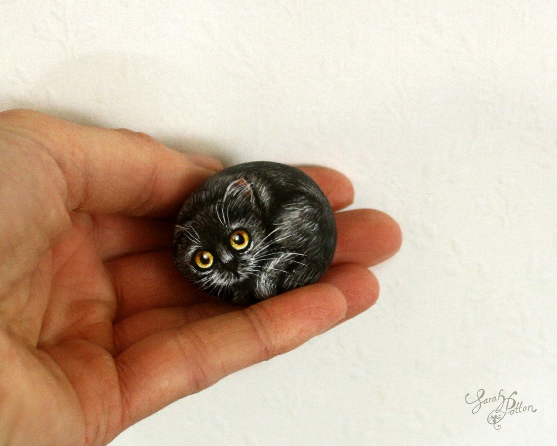 tiny painted stone of black cat
